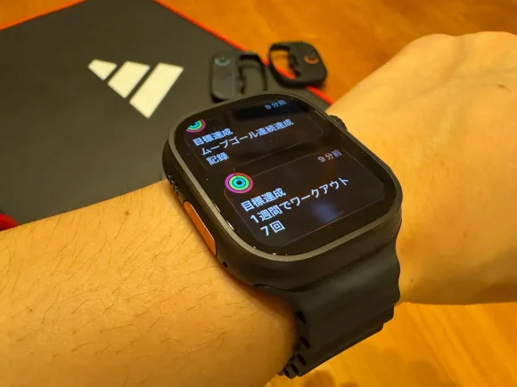 Apple Watch Ultra 2を着用した40代パパブロガーの腕。画面の「ワークアウト目標達成」の通知が、ハードな使用環境を証明。ブログの記事画像