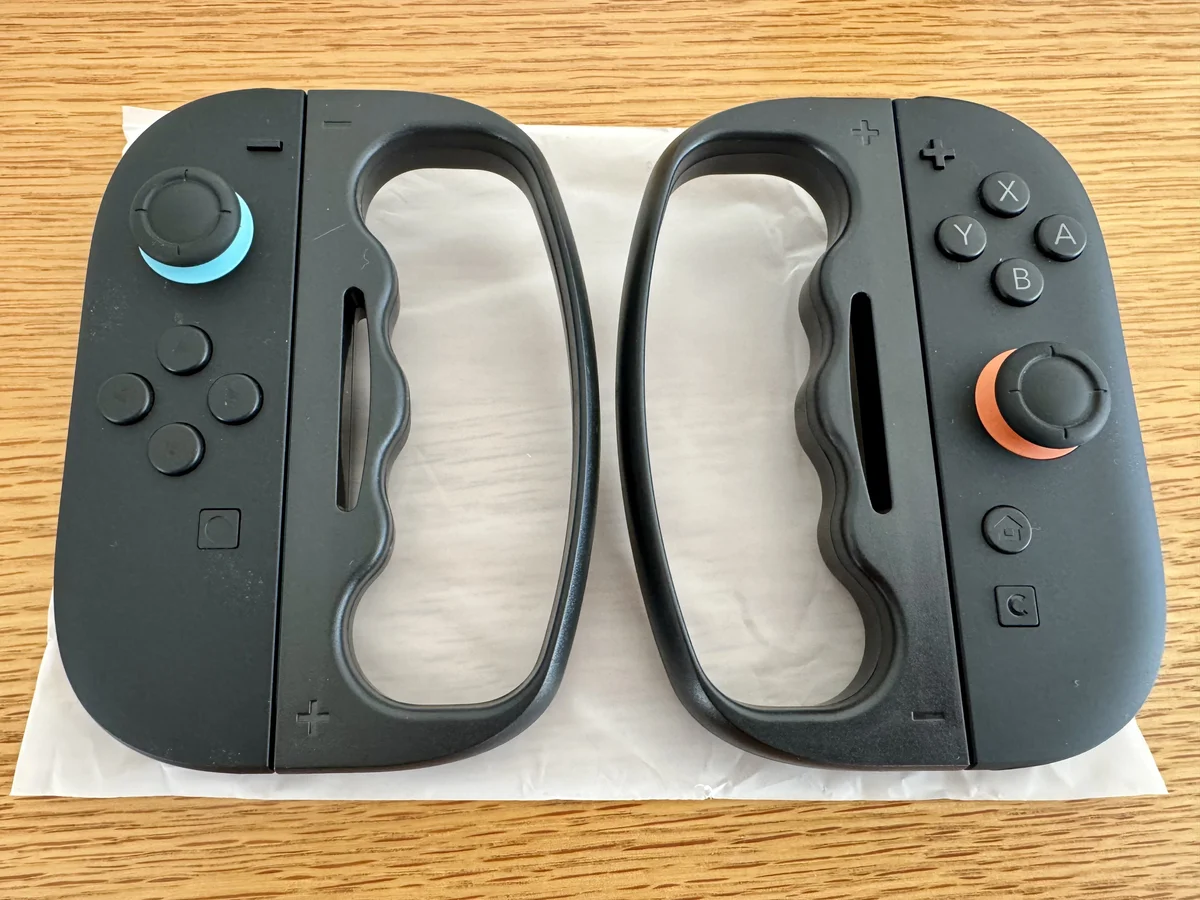 Joy-Con 2に装着したフィットボクシング用グリップ左右2個を木製テーブルに並べた様子