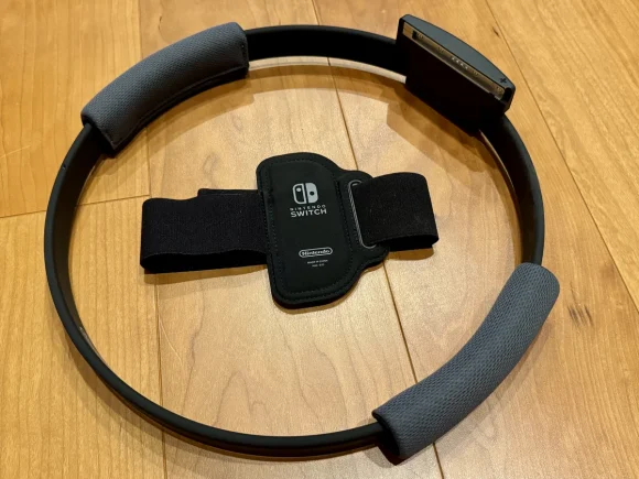 リングフィットアドベンチャーのリングコンとレッグバンドが床に置かれている。Joy-Conを差し込む部分とマジックテープのバンドが見える