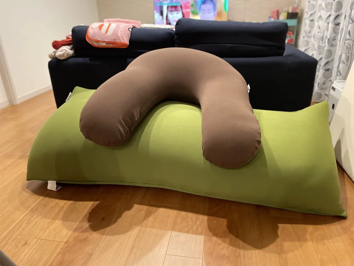 リビングでYogibo Maxの上にYogiboサポートを載せた状態。奥に紺色のソファ
