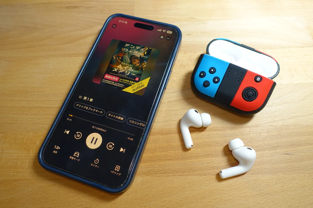 iPhoneのAudibleアプリで『プロジェクト・ヘイル・メアリー』を再生中の画面と、AirPods Pro 3・Joy-Con風のケース