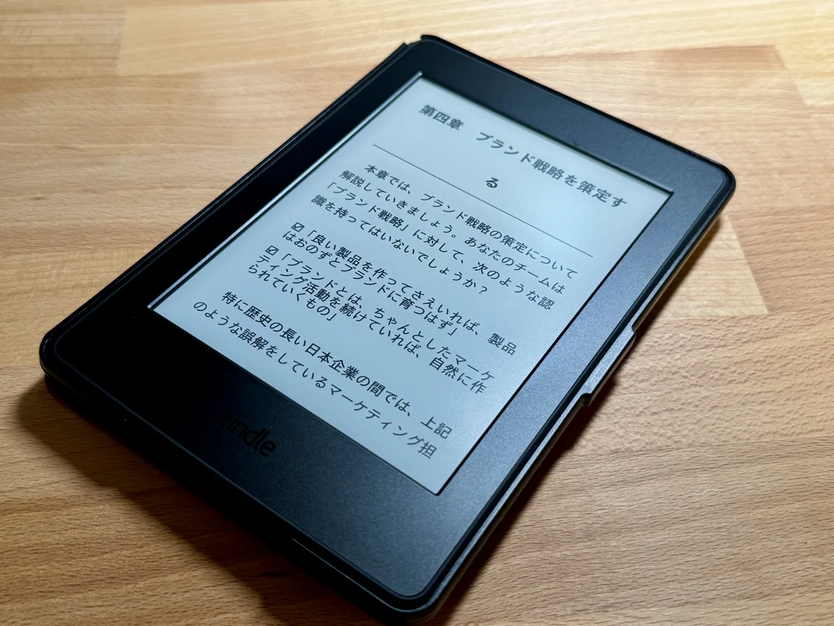 ボクのKindle Paperwhite。木の机の上で、ビジネス書の章の始まりのページを表示している