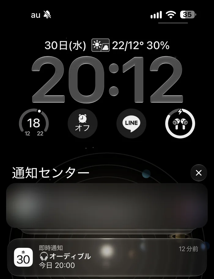 夜20時すぎのiPhoneのロック画面。通知センターに、カレンダーの「🎧オーディブル 今日 20:00」の通知が届いている