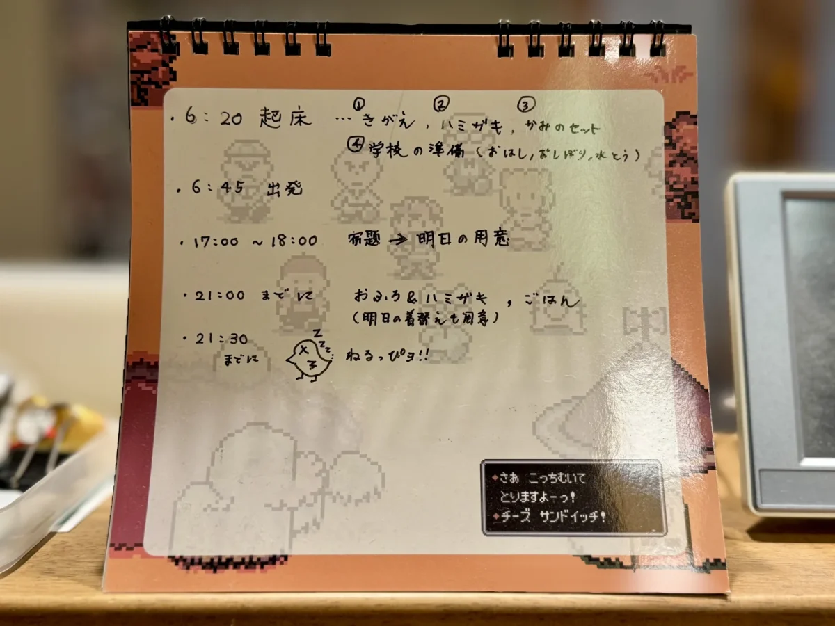 ほぼ日の卓上カレンダーのホワイトボード面に手書きした、子どもたちのゆるいスケジュール。朝の起床と出発、夕方は宿題から明日の用意、21時までにお風呂と歯みがきとごはん（明日の着替えも用意）、21時30分までに寝る